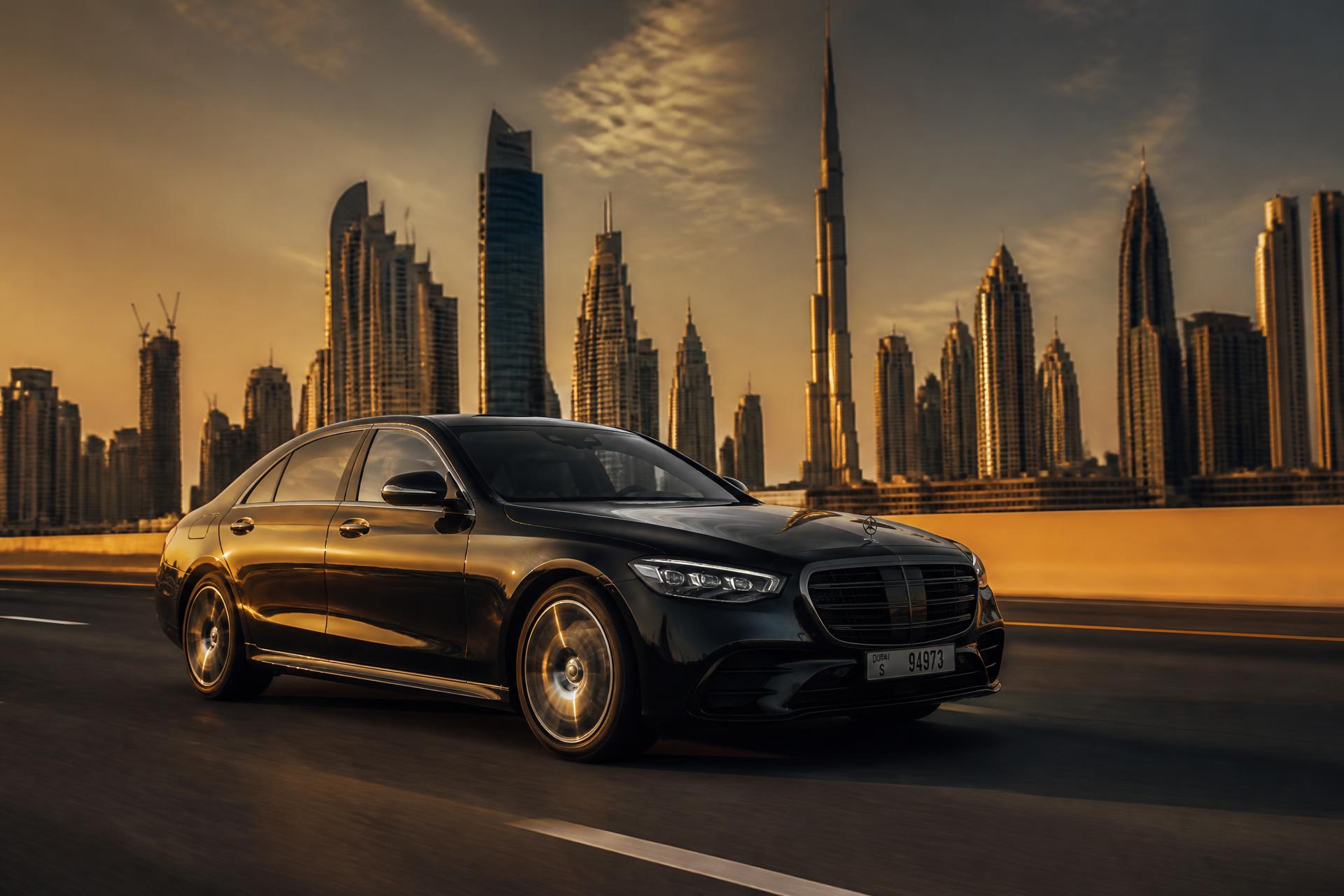 Luxury sedan on Sheikh Zayed Road, Dubai skyline at golden hour